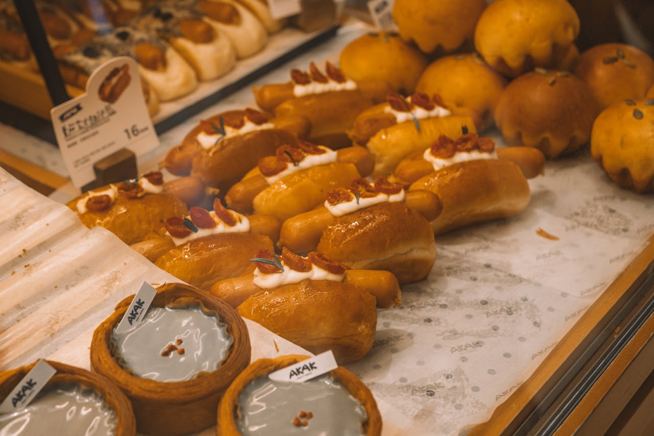 A display of fresh breads and pastries in a bakery setting, highlighting variety and texture.